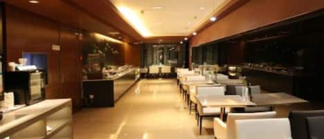 Un restaurant moderne avec un long comptoir et de nombreuses tables.