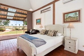 A bedroom with a bed, bedside tables, a chair, and artwork on the walls.
