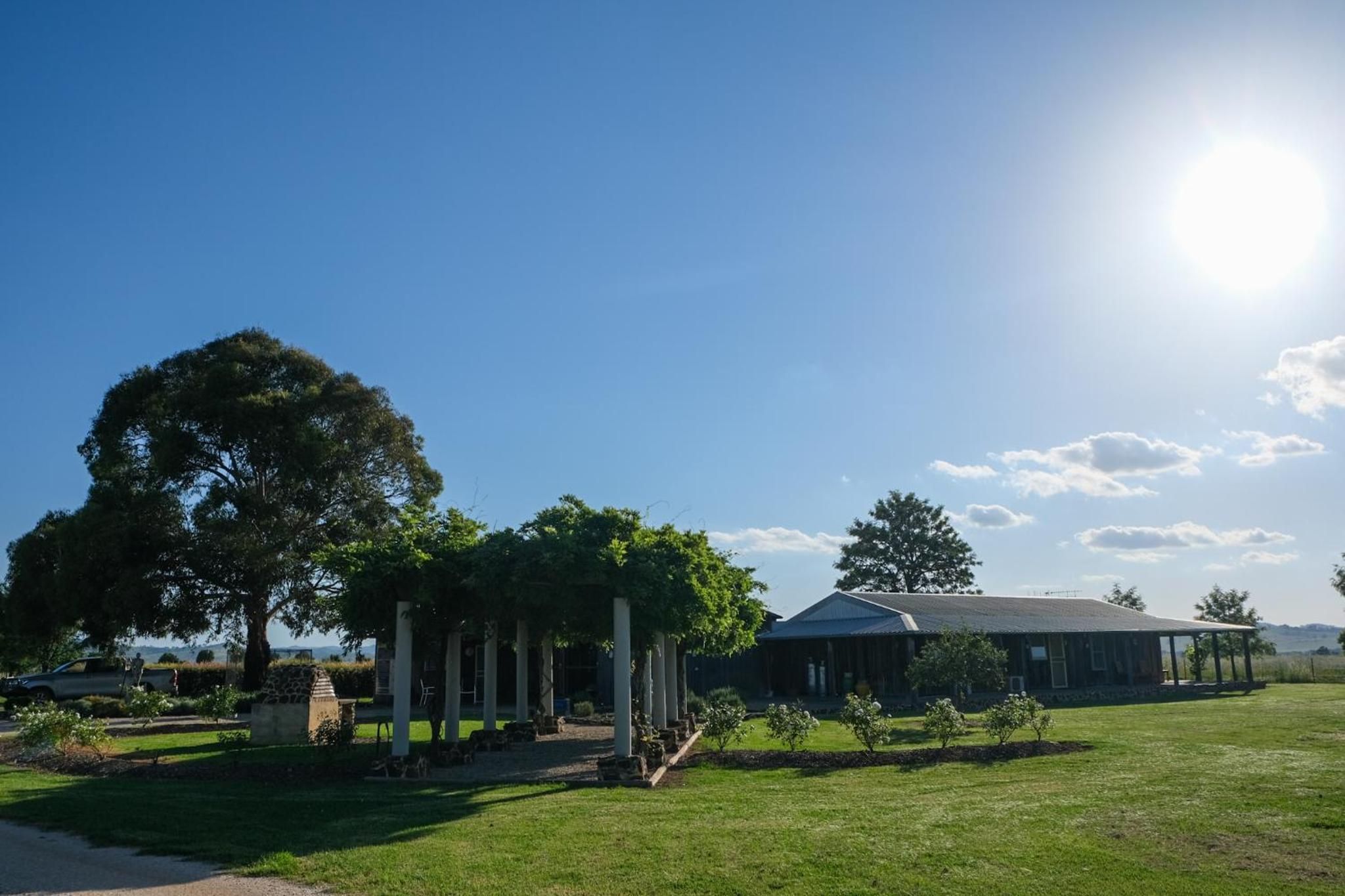 A building with a covered porch, surrounded by a well-maintained lawn and trees.