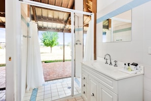 A bathroom with a shower, a sink, and a mirror. - Owl Head Lodge (Gulgong)