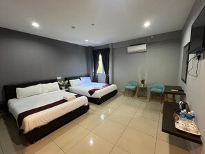 A hotel room with two beds, a desk, a chair, and an air conditioning unit. - Nah Hotel (Johor Bahru)