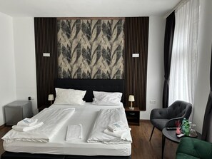 A hotel room with a bed, two bedside tables, a chair, a wall-mounted artwork, and a window with curtains. - Hotel Cafv Burg Stahleck (Bacharach)