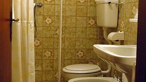 Une salle de bain avec douche, toilettes et lavabo.