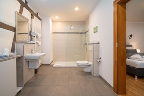 A modern bathroom with a shower, toilet, and sink. - Hotel Weingut Moselloreley (Piesport)