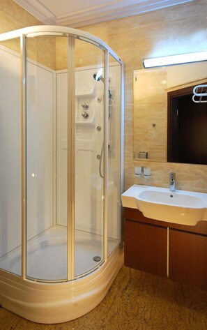 A modern bathroom with a glass-enclosed shower, a sink, and a mirror. - Hotel Victoria (Wloclawek)