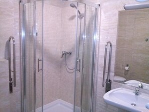 A shower enclosure with glass doors and a handheld showerhead. - Hotel Victoria (Wloclawek)