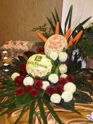A decorative arrangement with a watermelon centerpiece, flowers, and a sign that reads 'HOTEL Victoria'. - Hotel Victoria (Wloclawek)