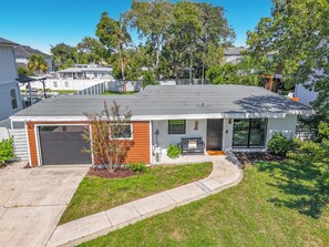 A modern two-story house with a garage, a covered porch, and a well-maintained lawn. - NEW! Pet-Friendly Modern Cottage, Steps to Jax Beach (Jacksonville Beach)
