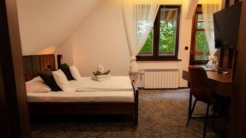 A bedroom with a bed, a desk, and a chair.