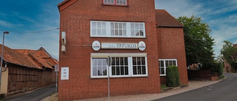A two-story brick building with a sign for 'ERFURTH' and 'Gastehof Hotel' indicating it is a hotel.