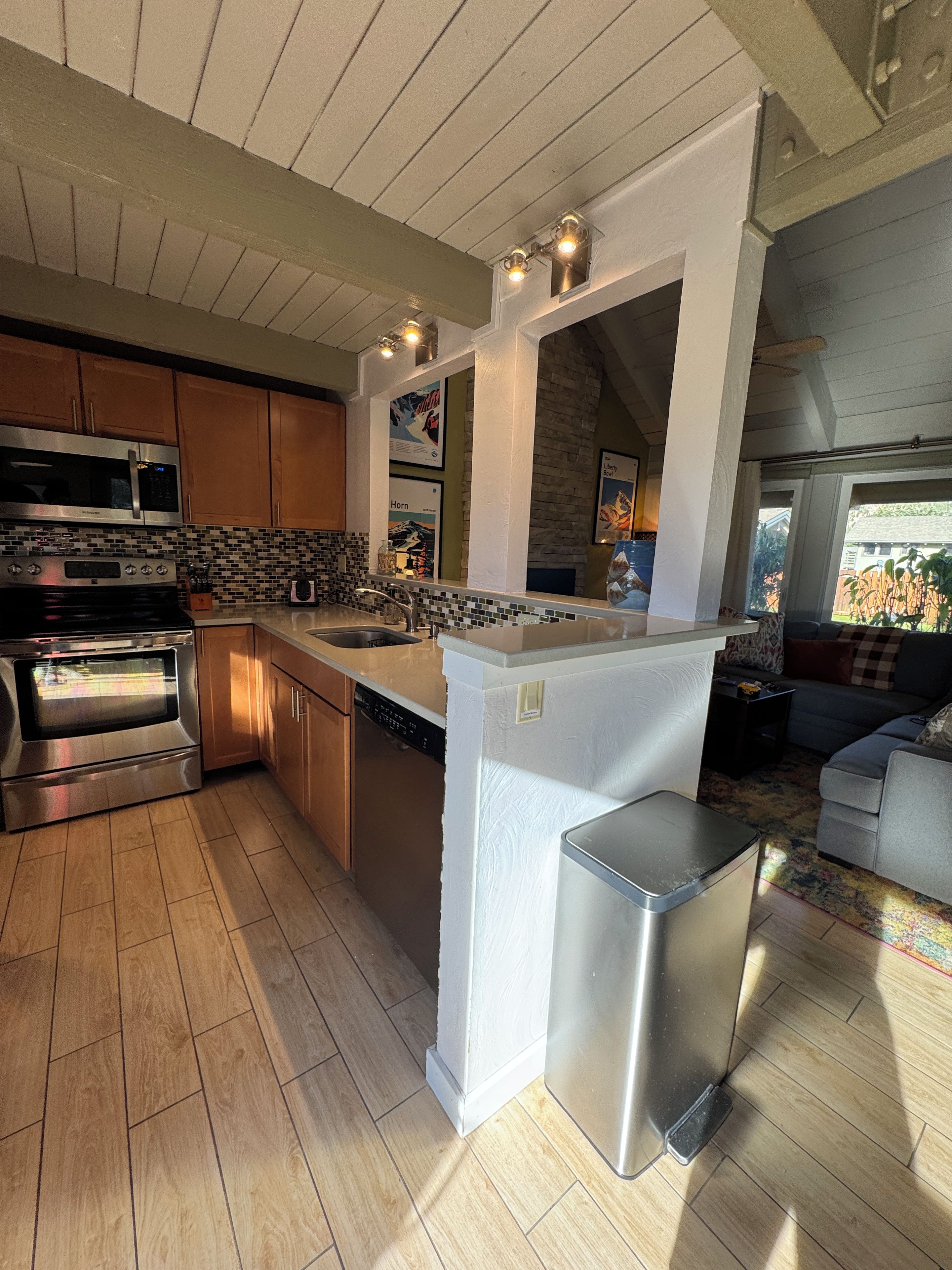 Una cocina moderna con electrodomésticos de acero inoxidable, una isla integrada y una pared de acento de piedra.