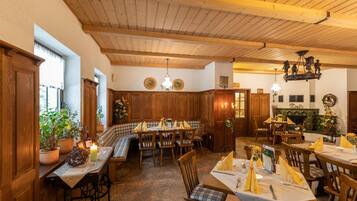 Ein Restaurant mit Holzvertäfelung, mehreren Tischen und Bänken.