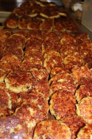 Una bandeja con varios alimentos, probablemente buñuelos o pasteles, dispuestos en filas.