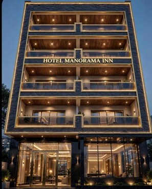 Et hotel med flere etager og et tydeligt skilt, der viser 'HOTEL MANORAMA INN'.