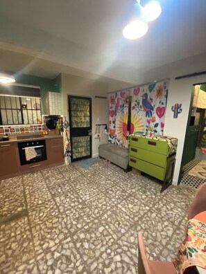 A room with a tiled floor, a sofa, a green dresser, and a window with a decorative curtain. - Superb 1-bedroom apartment in vibrant Ciudad de México (Ciudad de México)