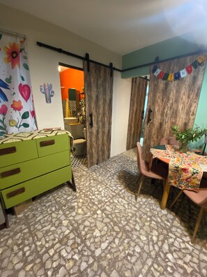 A room with a green dresser, a table with a floral tablecloth, and a door leading to another room. - Superb 1-bedroom apartment in vibrant Ciudad de México (Ciudad de México)