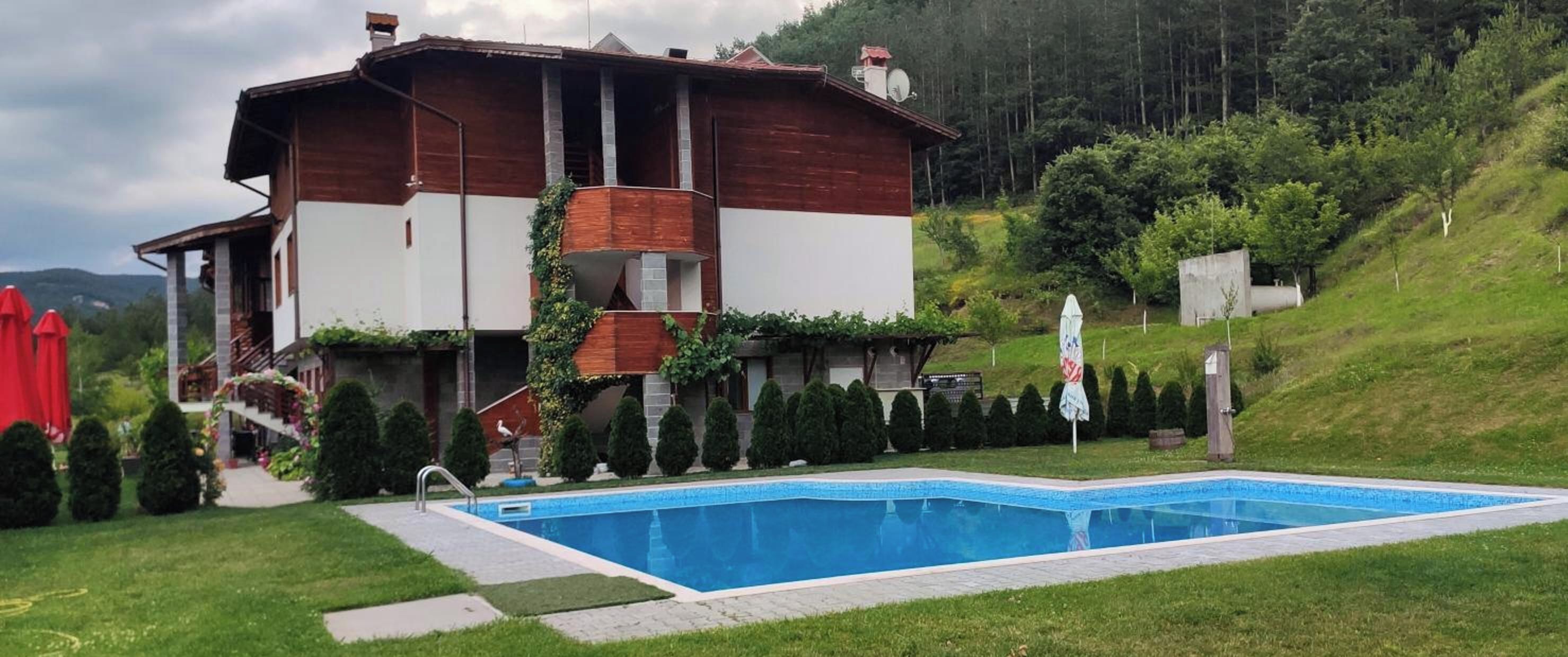 Une maison à deux étages avec une piscine à l’avant.