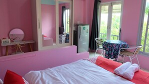A pink-themed room with a bed, a desk, a chair, a mirror, and a refrigerator. - Pop 75429 101 Place Navanakorn (Bangkok)