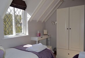 Un dormitorio con cama, ventana con vistas, armario y radiador.