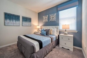 A bedroom with a bed, nightstands, and wall art. - Ultimate Resort Retreat, Stunning 6-bedroom Haven (Kissimmee)