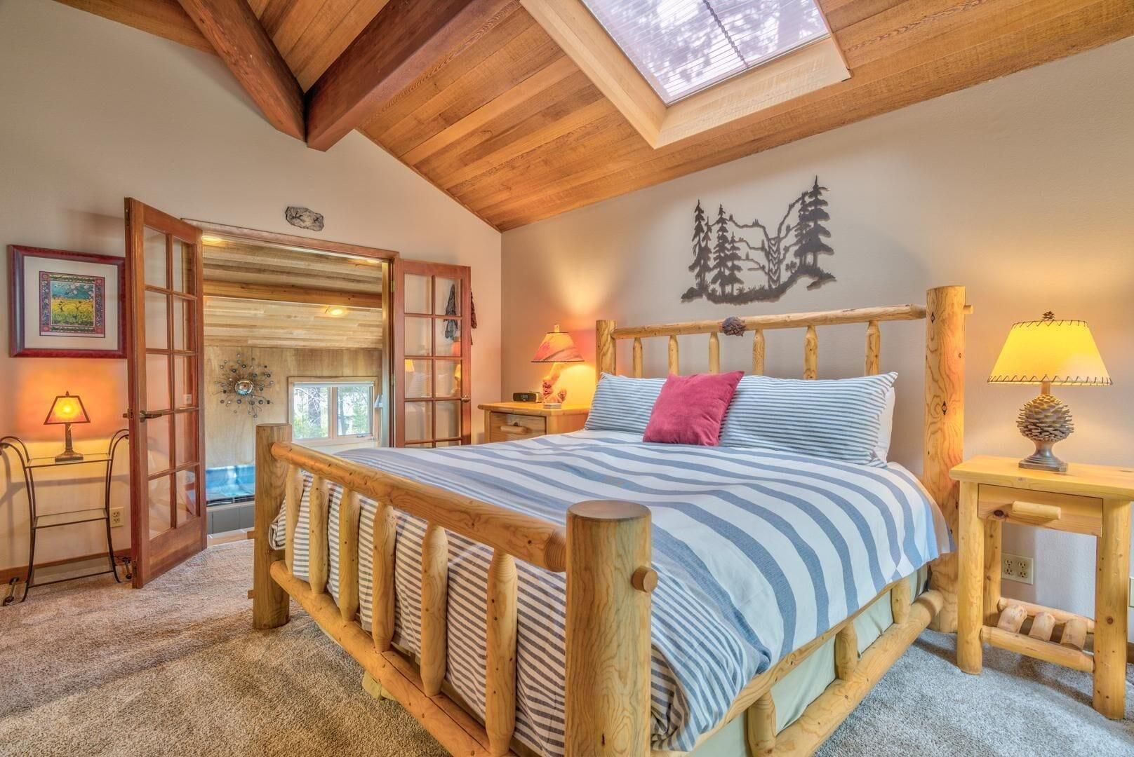 A cozy bedroom with a wooden bed frame, a skylight, and a decorative wall piece.