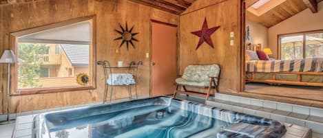 Une salle de spa dotée d’un bain à remous, de murs en bois, d’une décoration sur le thème des étoiles et d’une fenêtre offrant une vue agréable.