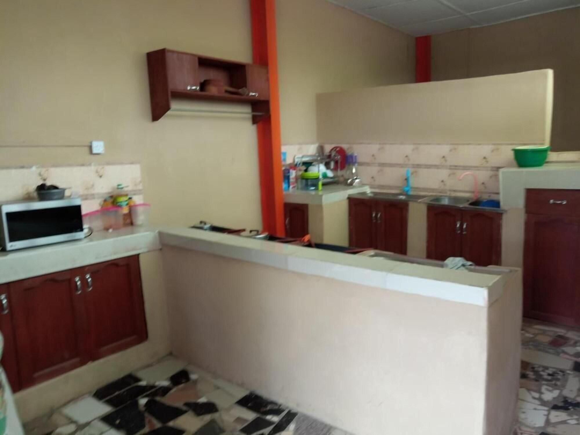 A compact kitchen with a microwave, sink, and cabinets.