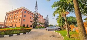A multi-story building with a parking area in front. - Villa Park Hotels (Lagos)