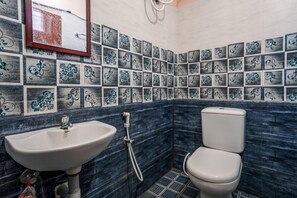 Un baño con lavamanos, inodoro y azulejos decorativos.