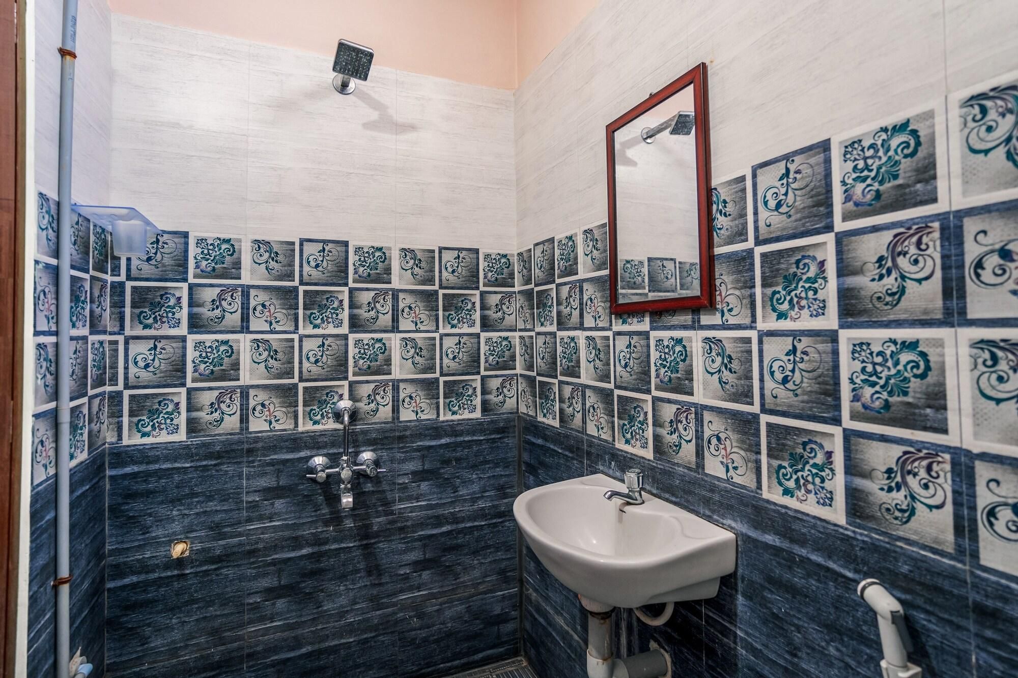A bathroom with a sink, mirror, and decorative tiles.