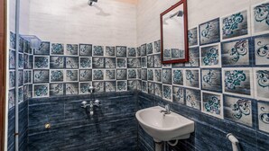 Un baño con lavamanos, espejo y azulejos decorativos.