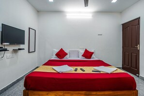 Una habitación de hotel con cama, televisión y puerta.