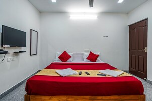 Una habitación de hotel con cama, televisión y puerta.