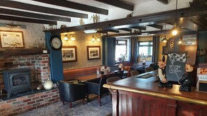 A pub interior with a bar, seating area, and a fireplace. - The Chequers Inn (Darlington)