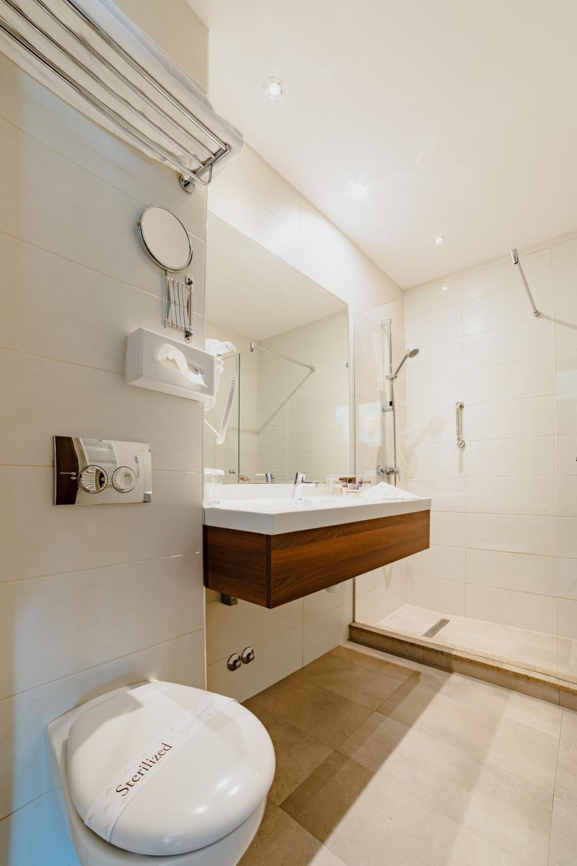 Une salle de bain moderne équipée de toilettes, d’un meuble-lavabo et d’une douche.