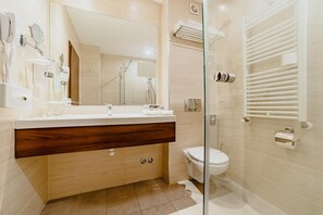 Un baño moderno con tocador de madera, cabina de ducha de vidrio y un inodoro.