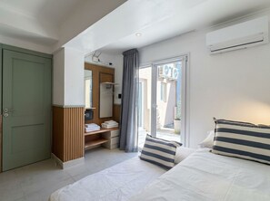 A hotel room with a bed, a wardrobe, a vanity with a mirror, and a sliding glass door to the outside. - A more spacious family apartment with a full kitchen. (Azul)