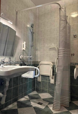 Un baño con ducha, lavabo e inodoro.