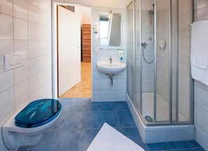 Un baño moderno con inodoro, lavamanos y ducha.