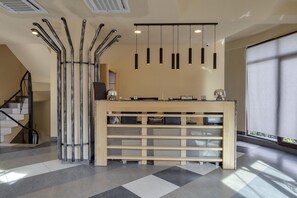 A reception desk with a modern design, a staircase with metal railings, and pendant lighting. - Savaneti Eco Hotel (Telavi)