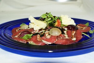 Un plato de comida con diversas carnes y vegetales.