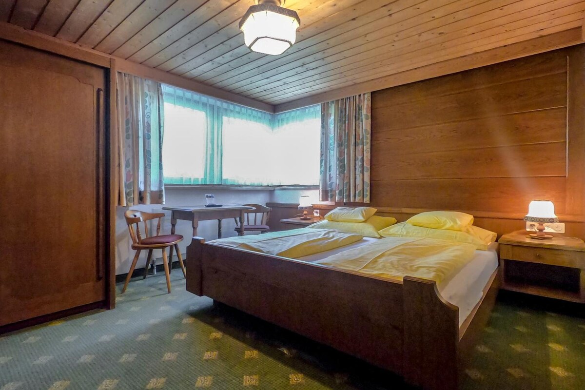 Una habitación con una cama, un escritorio y una silla.