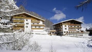 A hotel with multiple floors, a restaurant, and a ski lift in a snowy mountainous area.