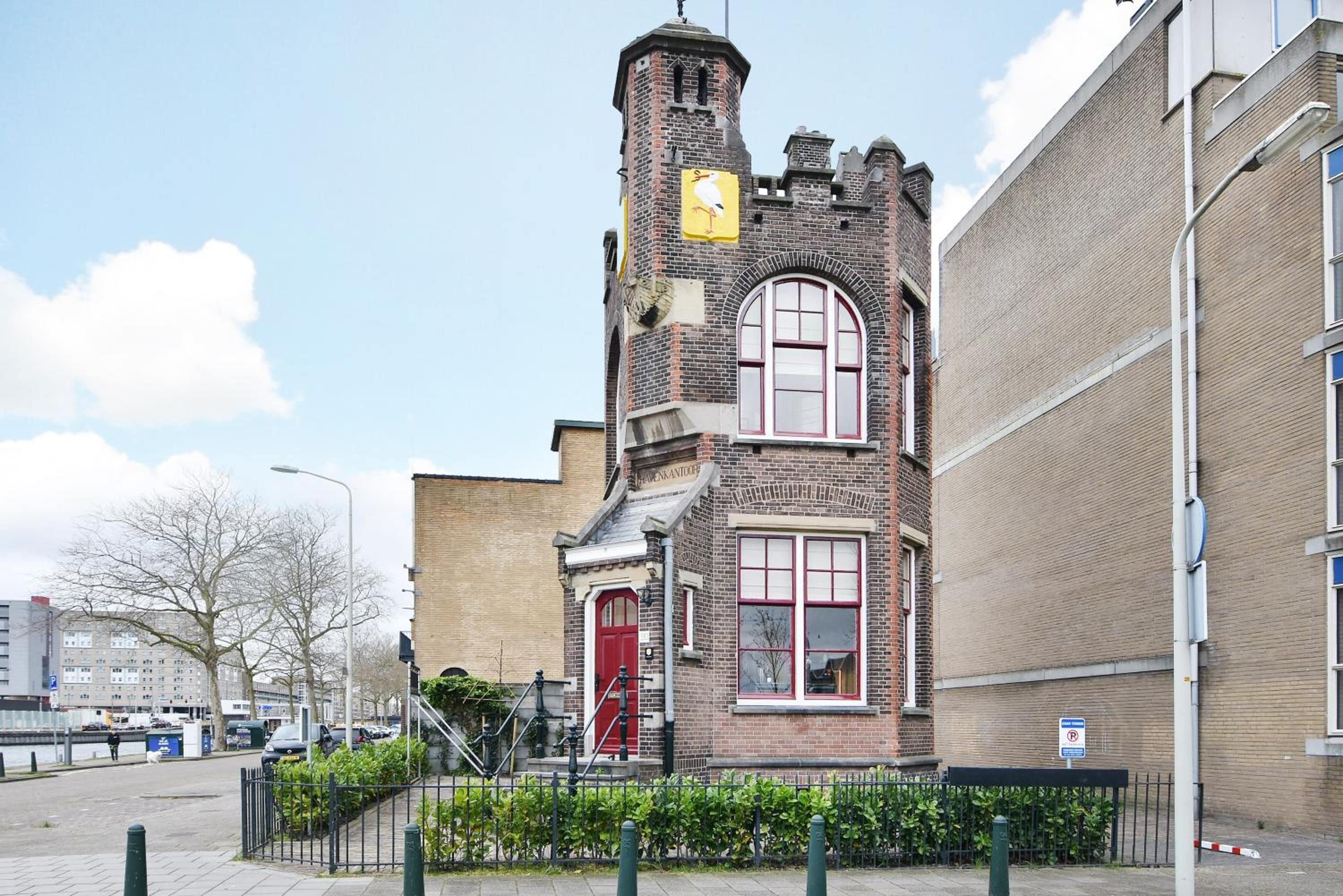 Een historisch gebouw met een opvallende toren en rondboogvensters.