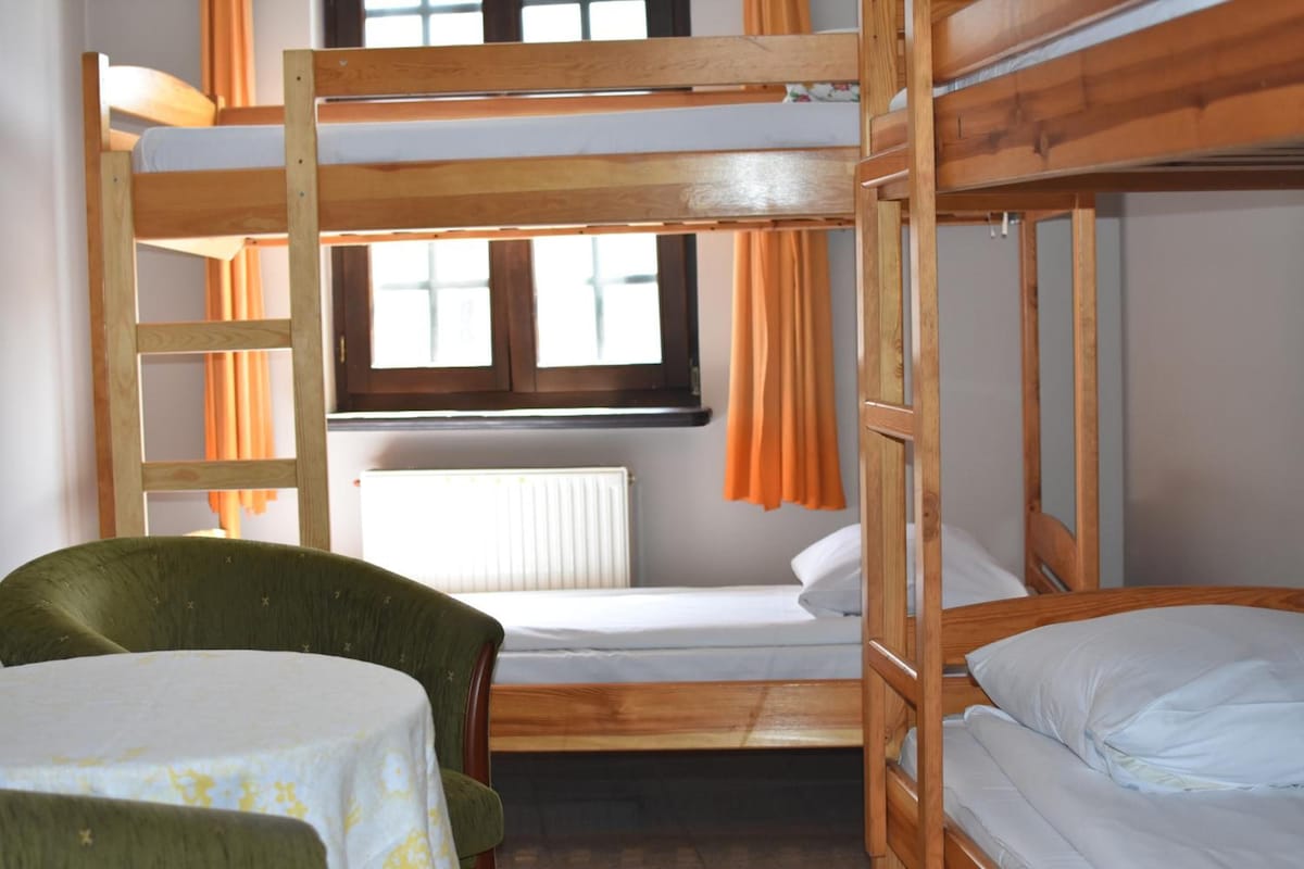 A bunk bed room with a table and a chair.