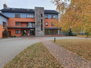 Un edificio moderno de dos pisos con fachada de piedra y techo plano.