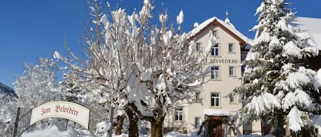A snow-covered building with a sign reading 'Zum Belvedere.'