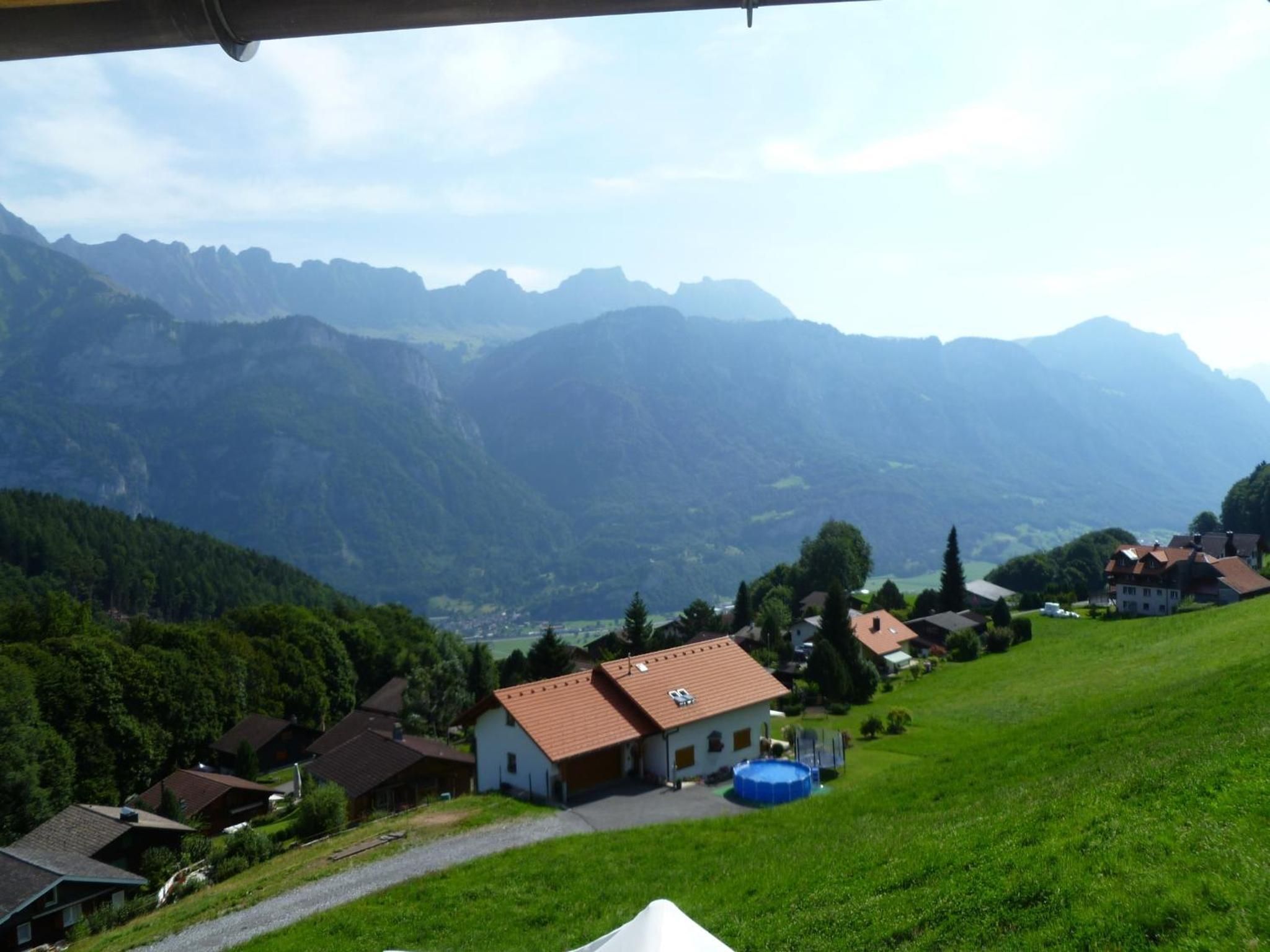 A residential area with houses, a swimming pool, and a view of mountains.