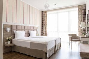 Een hotelkamer met een groot bed, een bureau en een stoel.