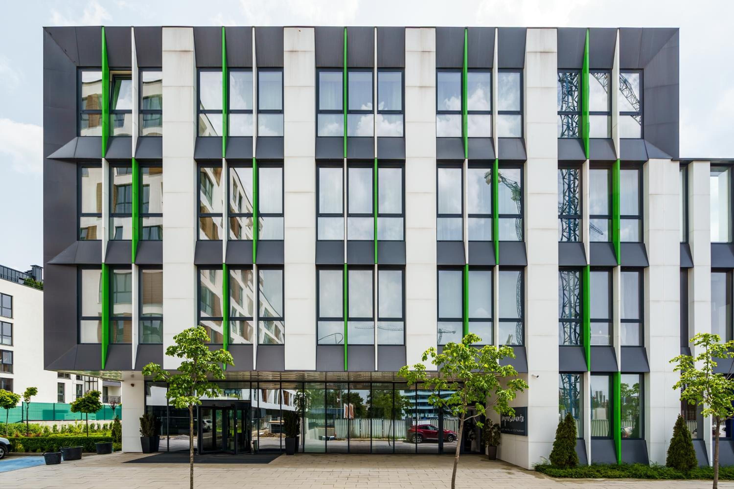 Un edificio moderno con fachada simétrica, ventanas amplias y una entrada central con puerta de vidrio.
